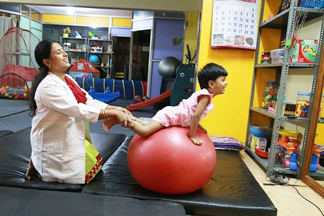 Child undergoing occupational therapy at a rehabilitation center with a special therapist, enhancing sensory processing and self-regulation